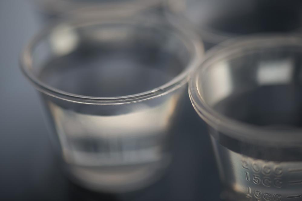 Small measuring cups filled with an ounce of water